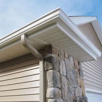Seamless gutter corner and downspout on a home with stone and siding